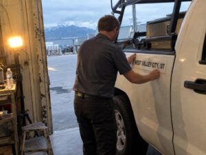 Applying a city name magnet before a service area job in West Valley City Ut by Aegis Heating and Air