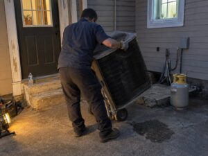 Removing an old condenser during a replacement in Installation by Aegis Heating and Air
