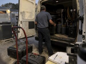 Loading assorted service equipment into a work truck in Refrigerant Recharge by Aegis Heating and Air